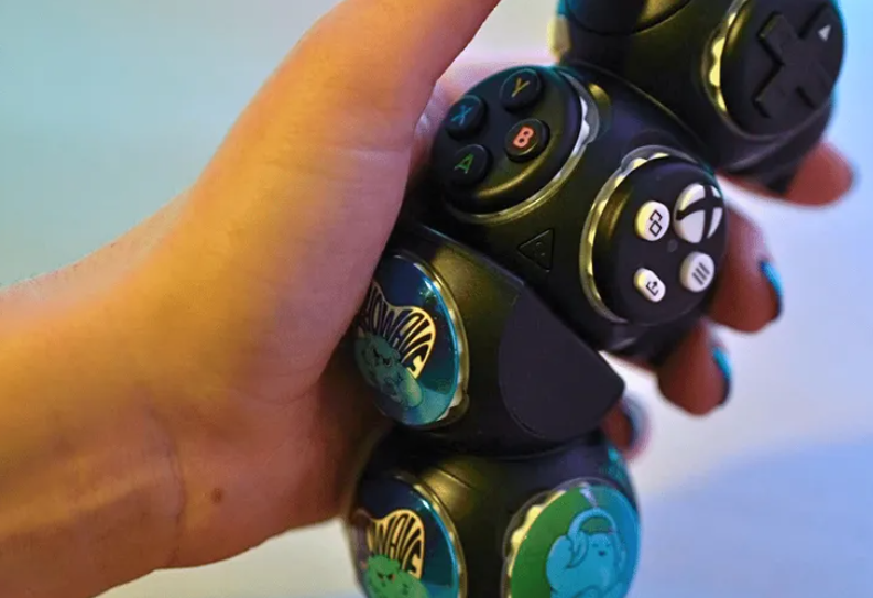 Image is of a hand holding the Proteus Controller.