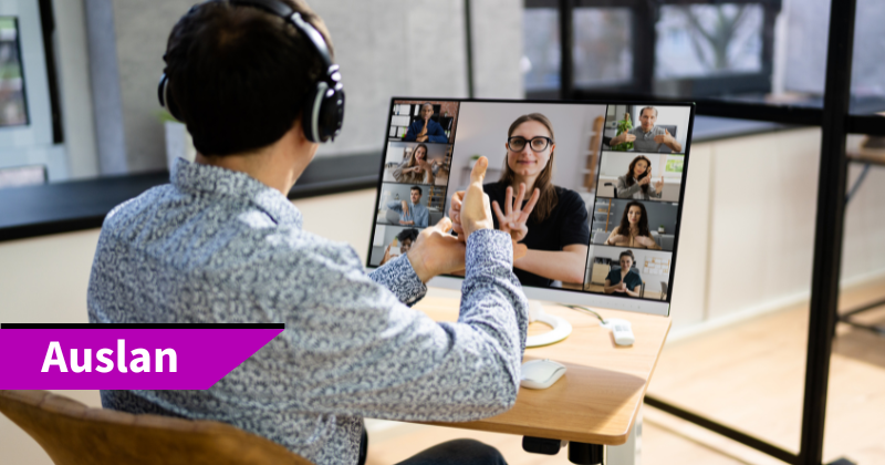 Text says Auslan. Image is of a man having a conversation in Auslan, with a woman on the screen of a laptop.