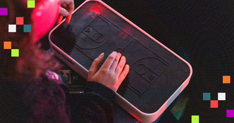 An image of the One Court device, with hands placed upon it.